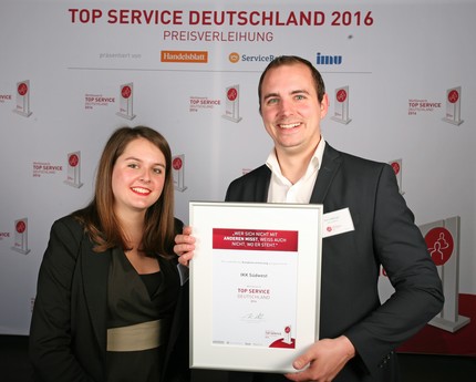 Kundenberaterin Sophie Jehle und Referent Service- und Qualitätsmanagement Sven Aderjan von der IKK Südwest halten die Auszeichnung „TOP SERVICE Deutschland 2016“ in die Kamera.