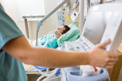 Arzt im Krankenhaus stellt medizinische Geräte ein.