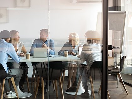 Eine Gruppe von Menschen, die in einem Besprechungsraum zusammensitzen