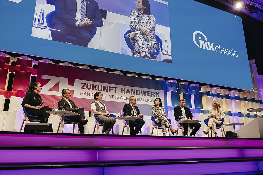 Personen, die bei einer Diskussionrunde der IKK classic auf der Bühne sitzen